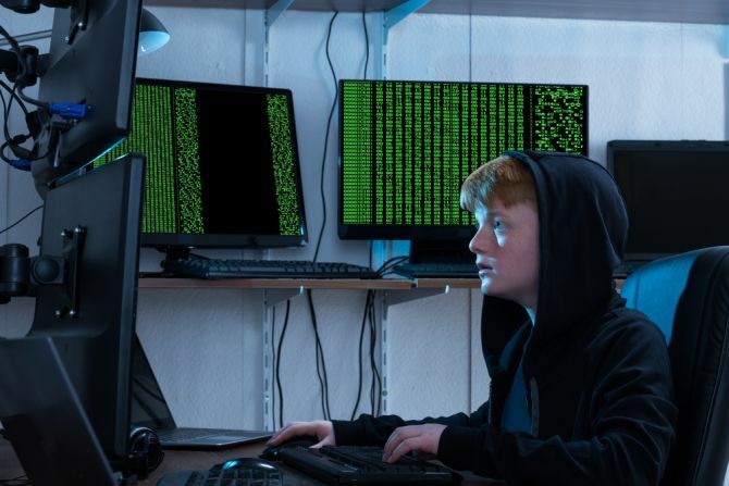 hacker teenager che utilizza più computer