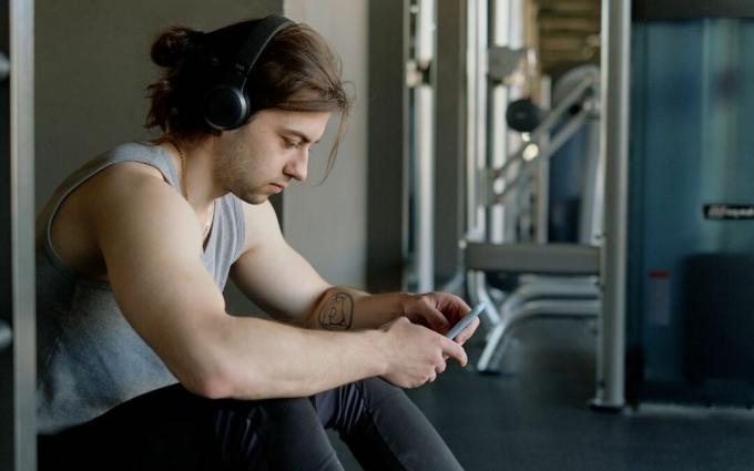 Uomo con le cuffie usando il suo smartphone