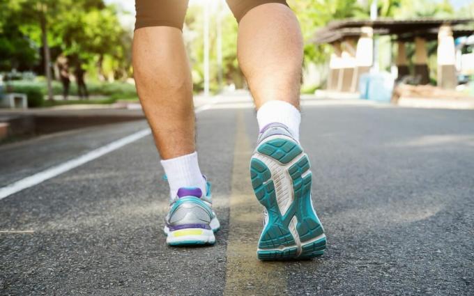 Piedi dell'atleta del corridore che corrono sulla strada