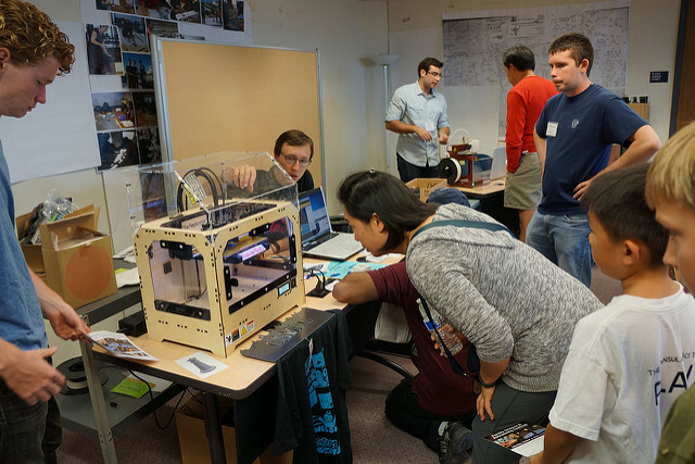 persone che guardano la stampante 3d